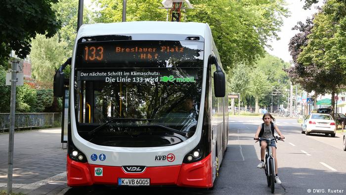 An E-bus and a cyclist cruise along Cologne's city streets | Elektrobus mit Batterie (DW/G. Rueter)