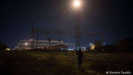 Ένας πρόσφυγας περπατά μόνος μέσα στη νύχτα, κατευθυνόμενος προς τα σταματημένα τρένα. Ελπίζει ότι με κάποιο τρόπο θα καταφέρει να φτάσει στην Κροατία κι από κει σε κάποια άλλη ευρωπαϊκή χώρα.