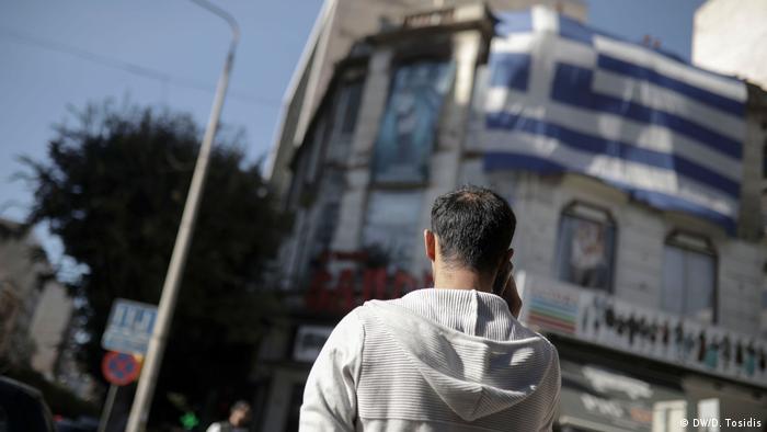 Mohammed speaks to his smuggler on the phone on a street in Greece