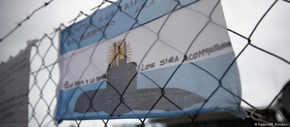 Bandeira argentina na cerca da base naval de Mar del Plata com mensagem de apoio aos 44 tripulantes