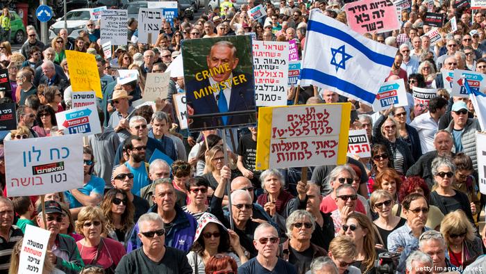 Israeli protesters raise signs and shout slogans as they demonstrate against Prime Minister Benjamin Netanyahu (photo: Getty Images/J.Guez)