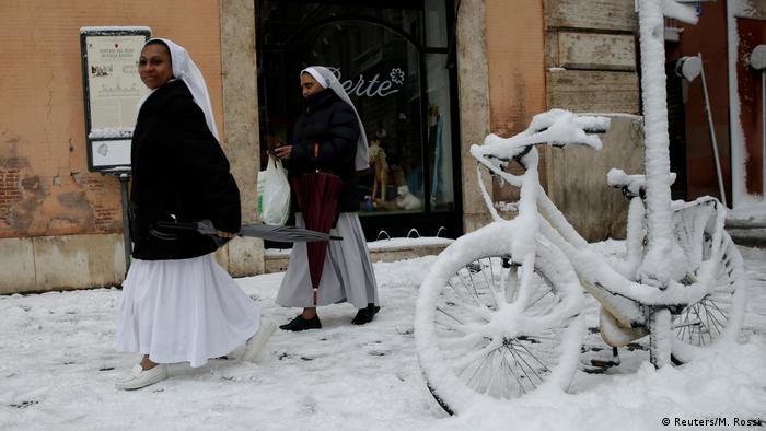 Freiras caminham nas ruas cobertas de neve na capital italiana