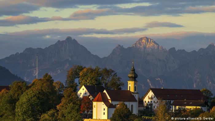 The Alps loom in the distance, in the foreground a small Bavarian chapel (picture-alliance/S. Derder)