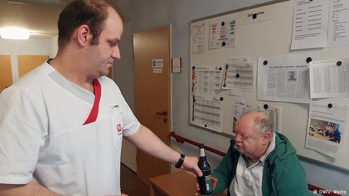 Заведующий отделением Кристоф Хайнце выдает постояльцу бутылку пива