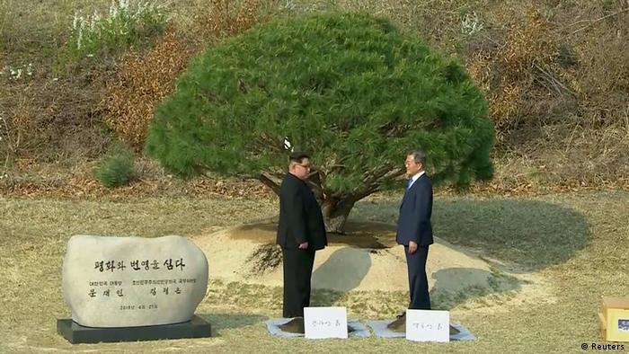 Kim Jong Un and Moon Jae-in face each other during a tree-planting ceremony (Reuters)