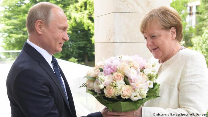 Putin reicht Merkel "Weiße Rosen"