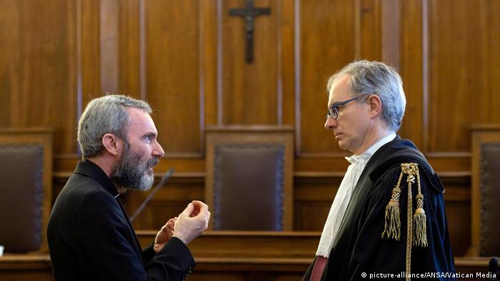 Monsignor Carlo Alberto Capella, left speaks with his lawyer Roberto Borgogno.