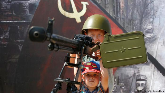 Children play with a Soviet-era machine gun (Reuters/S. Karpukhin)