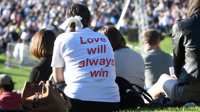 O amor sempre vencerá escrito em camisa de participante sentada no gramado em vigília no estádio Basin Reserve