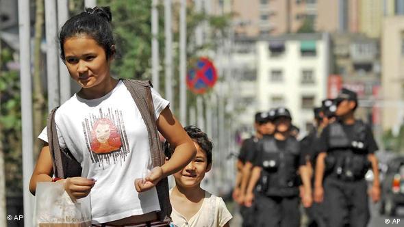 China Xinjiang Frau und Kind vor Polizeitruppe (AP)