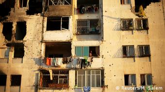 Palestinians look out a residential building that witnesses said was badly damaged by Israeli shelling in summer 2014 in Beit Lahiya in the northern Gaza Strip