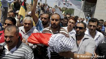 Mourners with the body of a Palestinian baby killed after his family's house was set fire by Israeli settlers