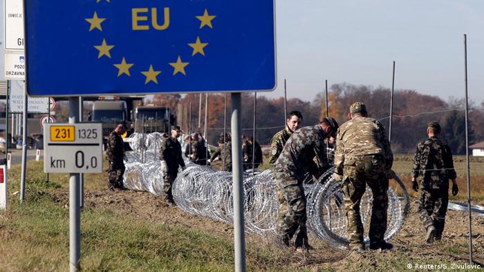Soldați sloveni ridică un gard de sârmă ghimpată la frontiera cu Croația