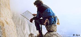 Messner lee un periódico sentado sobre una roca, a una altura que apunaría a muchos.