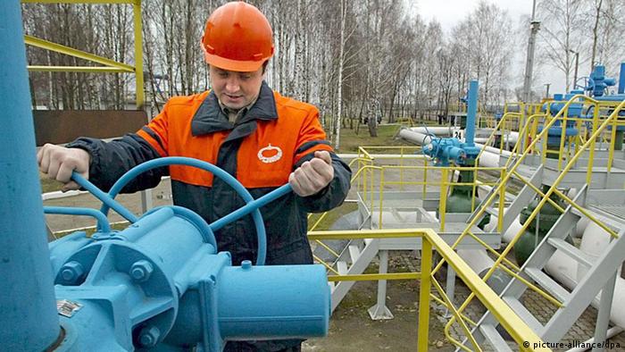 A Belarusian worker turns a valve (picture-alliance/dpa)