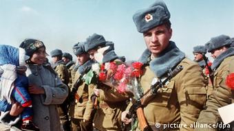1989: Σοβιετικοί στρατιώτες επιστρέφουν στην πατρίδα τους, κρατώντας κόκκινα γαρύφαλα