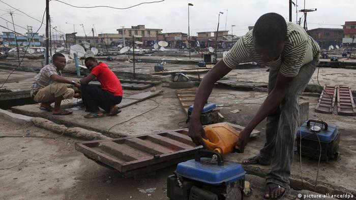 A man refuels a small generator in Lagos