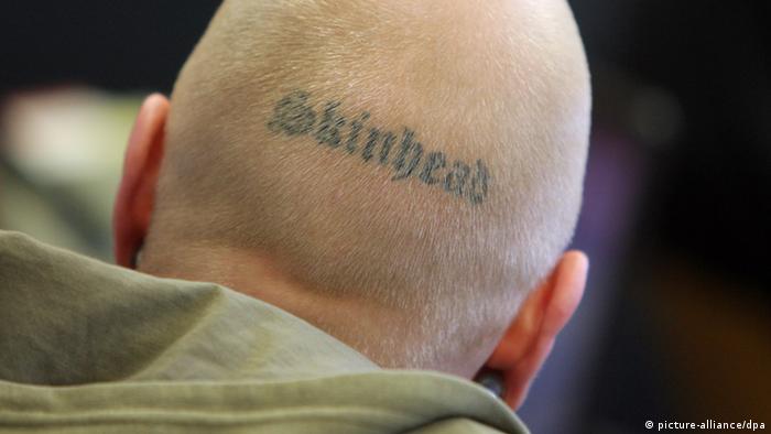 Cabeça de homem com tatuagem em que se lê Skinhead 