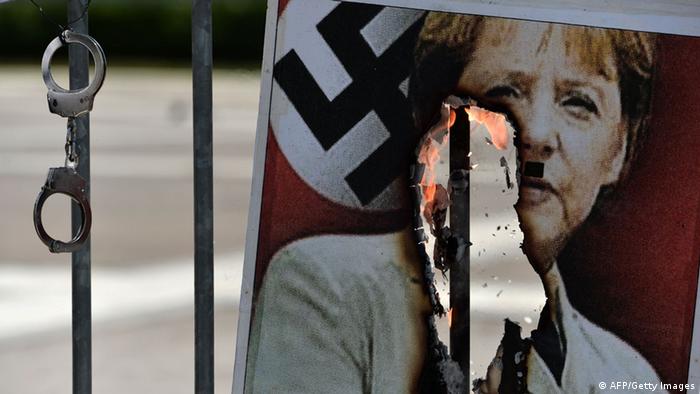 Burrning picture of Angela Merkel with swastika (AFP/Getty Images)