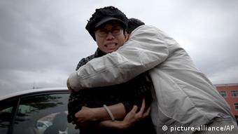 A relative comforts Liu Xia, left, wife of imprisoned Nobel Peace Prize winner Liu Xiaobo, while she cries outside Huairou Detention Center where her brother Liu Hui has been jailed in Huairou district, on the outskirts of Beijing, China, Sunday, June 9, 2013. A court sentenced Liu Hui, the brother-in-law of China's imprisoned Nobel Peace Prize winner Liu Xiaobo, to 11 years in prison Sunday — an unusually harsh punishment for a business dispute that the activist's wife immediately decried as a warning to the whole family. (AP Photo/Alexander F. Yuan)