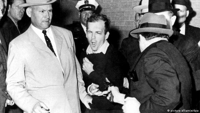 Jack Ruby (d) mata o suposto autor do atentado contra JFK, Lee Harvey Osswald (no centro)