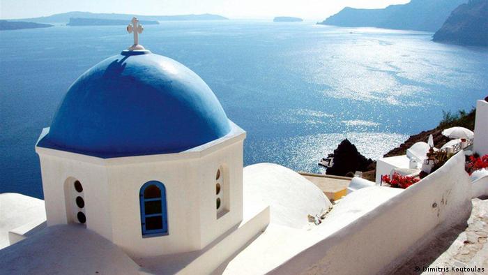 a white church with a blue dome on the island Santorini, Greece (Dimitris Koutoulas)