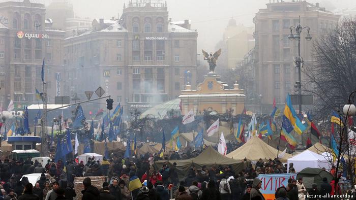 Multidão, bandeiras, fumaça no centro de Kiev