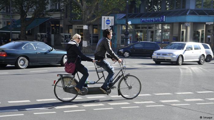 Two passengers ride a tandem bicycle in Berlin, Germany