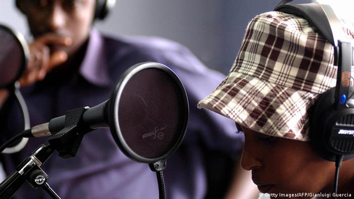 Two journalists speak at a radio station in Rwanda