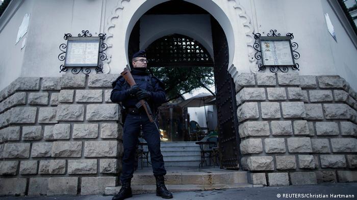 A French police officer stands guard in front of the entrance of the Paris Grand Mosque