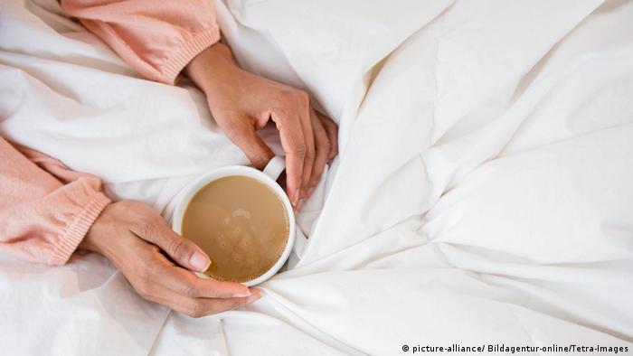 Frau mit Kaffeetasse im Bett (picture-alliance/ Bildagentur-online/Tetra-Images)