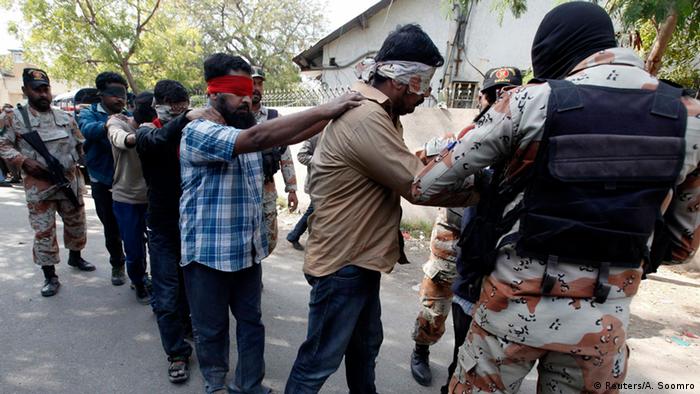 Paramilitary soldiers escort blindfolded men, who were detained during Wednesday's raid on the Muttahida Qaumi Movement (MQM) political party headquarters, after presenting them before an anti-terrorism court in Karachi March 12, 2015 (Photo: REUTERS/Akhtar Soomro)