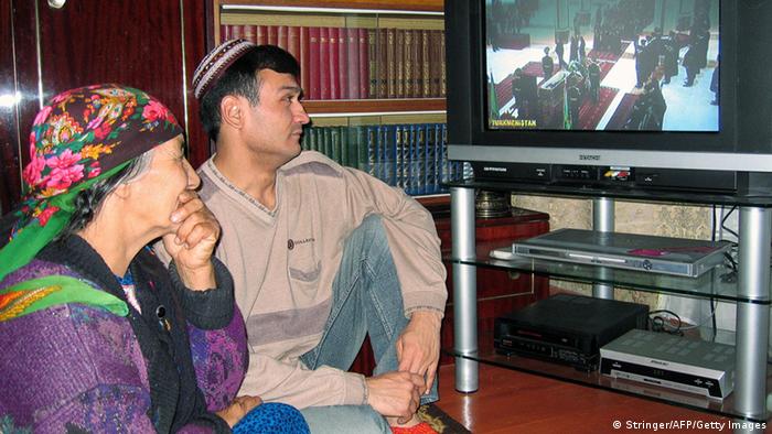 Turkmen couple in front of the TV screen