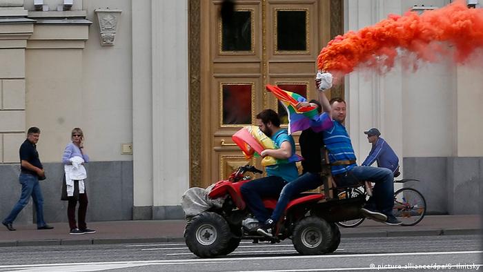 LGBT acitivsts drive by Moscow's mayor office holding a flare and rainbow flag riding on a quad-bike during an unauthorized gay rights activists rally (picture-alliance/dpa/S. Ilnitsky)
