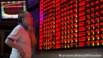Мужчина смотрит на курсы акций на Шанхайской фондовой бирже