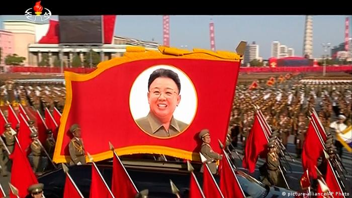 A flag with the picture of Kim Jong Il at a military parade (picture-alliance/AP Photo)