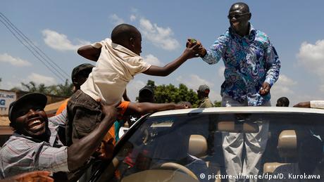 Uganda Kampala Oppositionsführer Kizza Besigye im offenen Wagen grüßt Kind