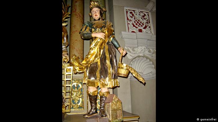 Statue of St Florian, wearing uniform of a Roman soldier and carryiung a bucket of water 