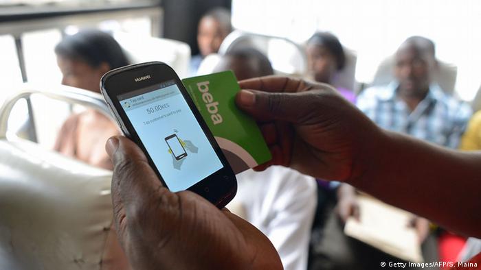 A hand holding a smartphone and a BebaPay card (Getty Images/AFP/S. Maina)