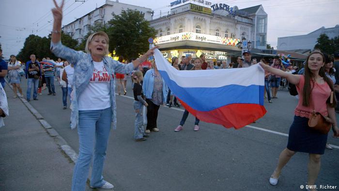 Frauen mit einer russischen Flagge freuen sich über den Anschluss der Krim an Russland.