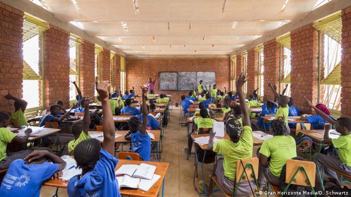 Children raise their hands in a school classroom