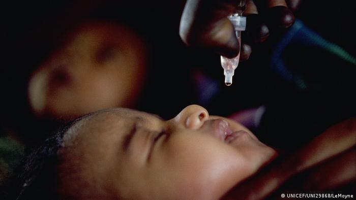 A baby receives a dose of oral polio vaccine in Sudan