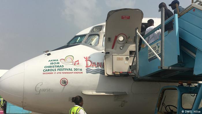 Plane on tarmac bearing advert for Akwa Ibom Christmas Carols Festival 