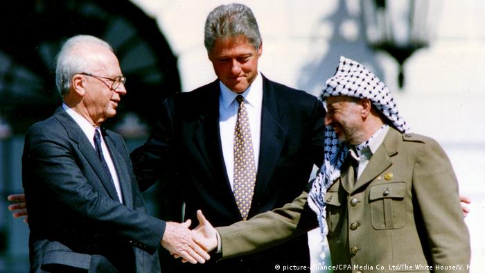 Ицхак Рабин и Ясер Арафат си подават ръка под погледа на Бил Клинтън
