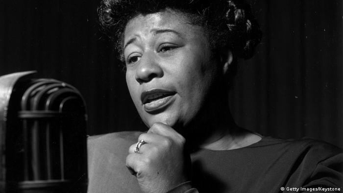 Ella Fitzgerald standing in front of a microphone