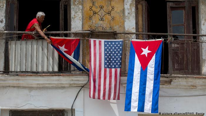 Bandeiras dos EUA e de Cuba em fachada de prÃ©dio em Havana