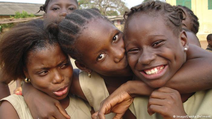 Three African schoolgirls hugging and kissing (Imago/Danita Delimont)