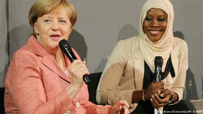 Angela Merkel con Nyima Jadama, refugiada de Gambia.