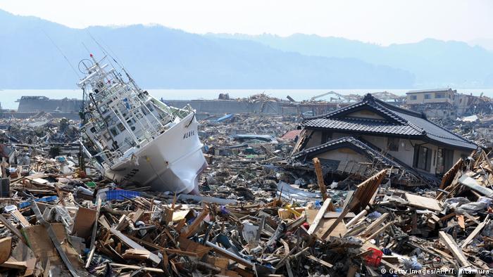 Barco de pesca em meio a escombros dezenas de metros da costa, em Otsuchi, no Japão, após um tsunami em 2011