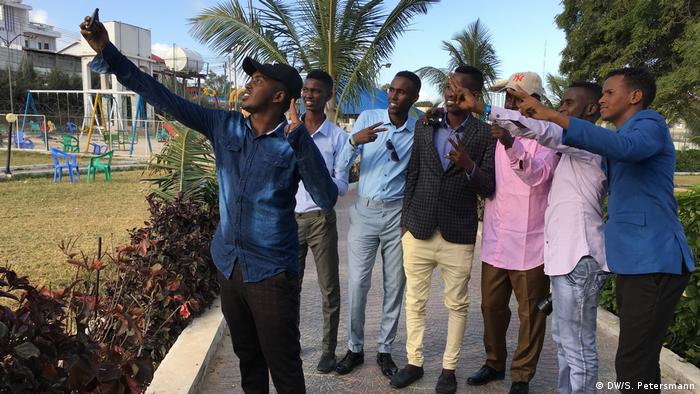 A group of young men take a 'selfie' in Peace Park (DW/S. Petersmann)